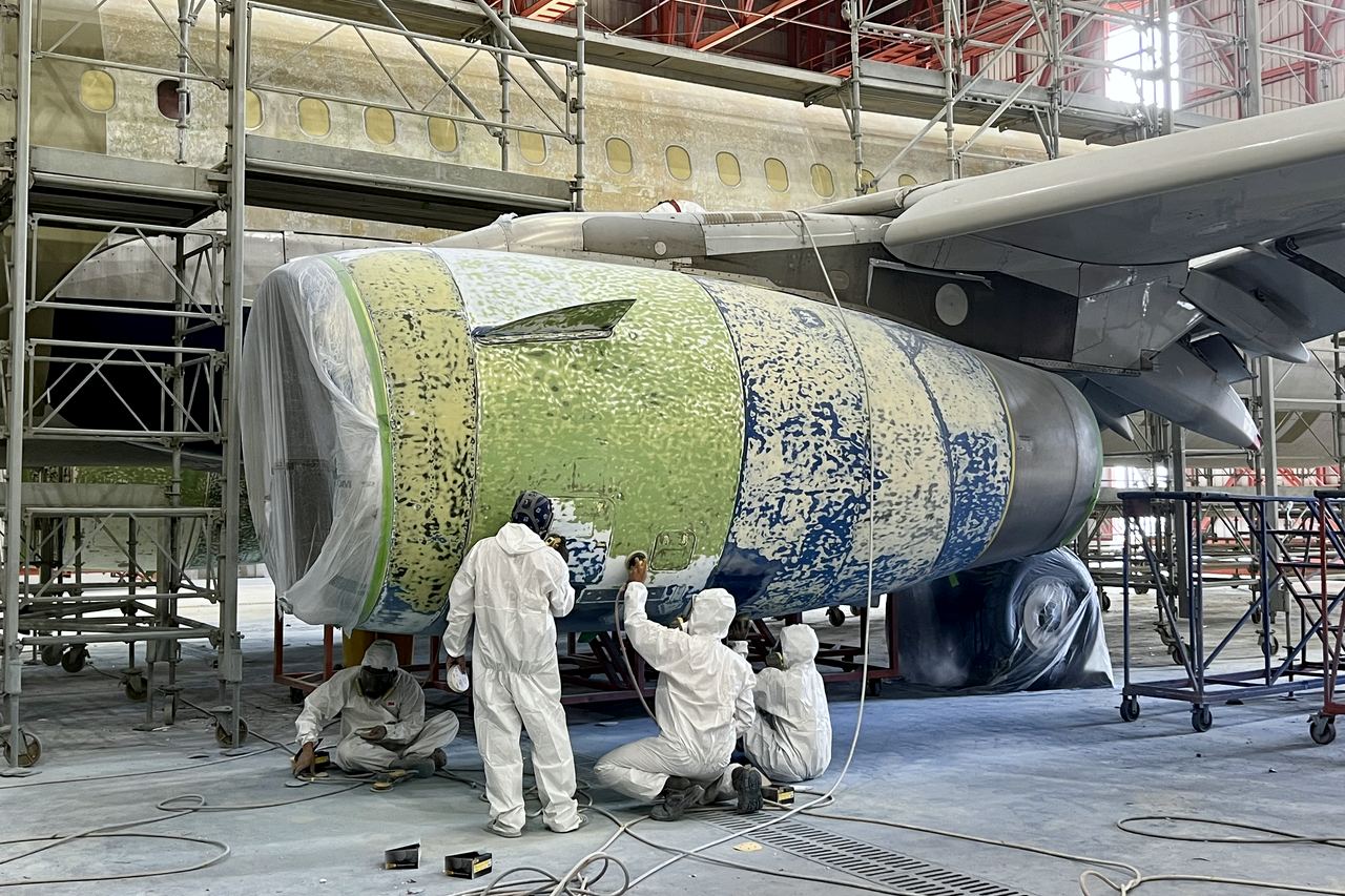 Team working an engine cowl