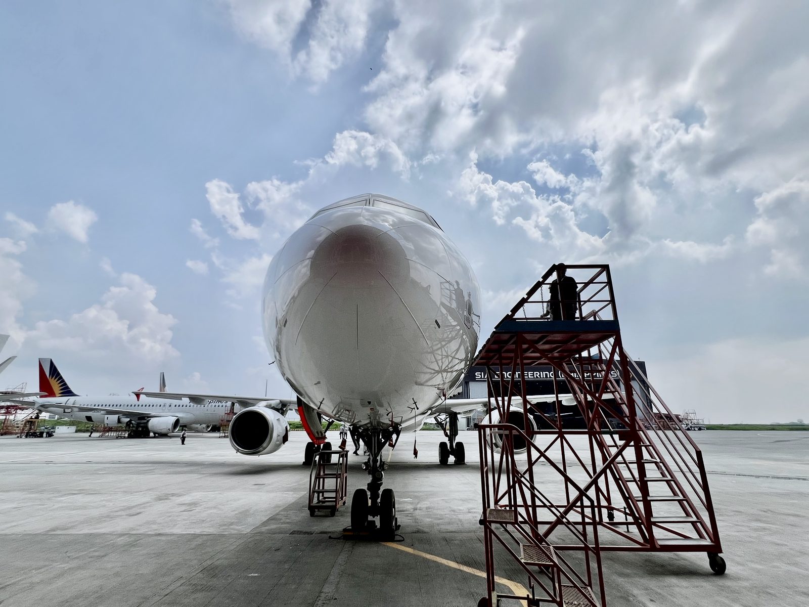Engineer surveying an aircraft nose from an access stand during a pre-purchase inspection